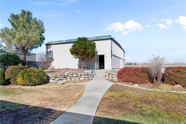 view of front of home featuring fence and an outbuilding