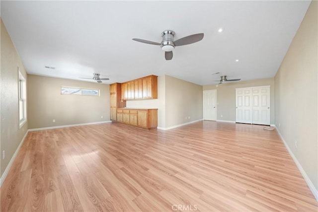 unfurnished living room with baseboards, a ceiling fan, and light wood finished floors