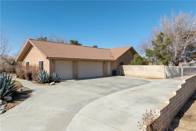 view of property exterior with a tile roof, cooling unit, stucco siding, and fence