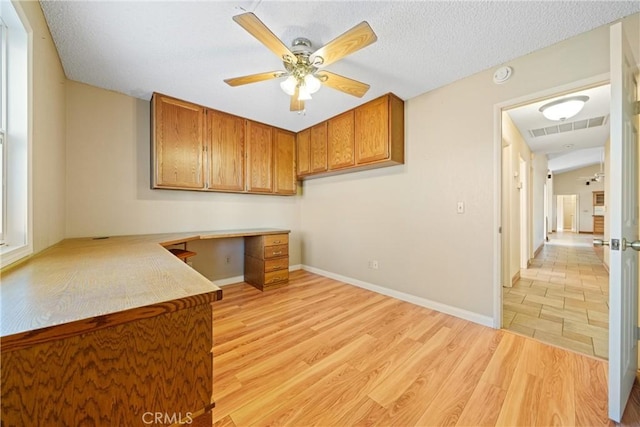 kitchen with visible vents, ceiling fan, light countertops, light wood-style floors, and brown cabinetry