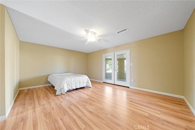bedroom featuring light wood-style flooring, visible vents, baseboards, french doors, and access to outside