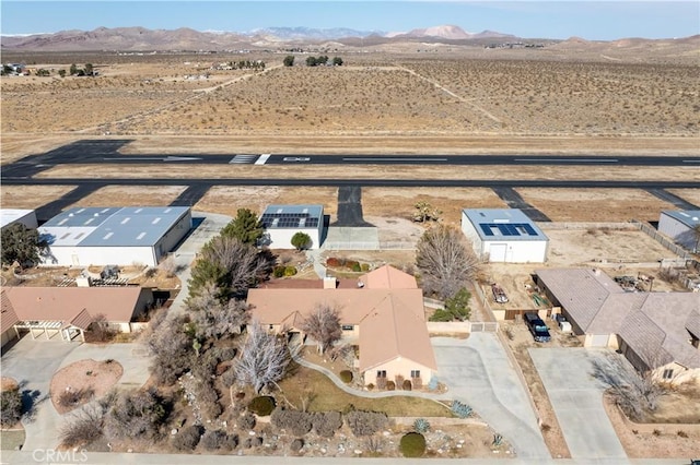 drone / aerial view featuring a mountain view and a desert view