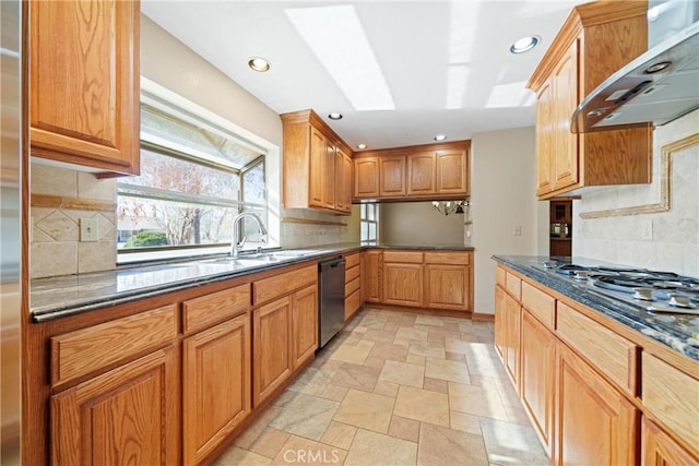 kitchen with stone tile floors, dishwashing machine, decorative backsplash, and wall chimney exhaust hood