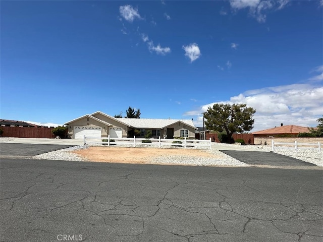 view of front of house with a garage, fence private yard, and concrete driveway