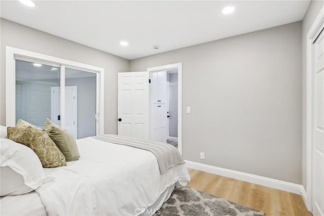 bedroom with baseboards, recessed lighting, and light wood-type flooring