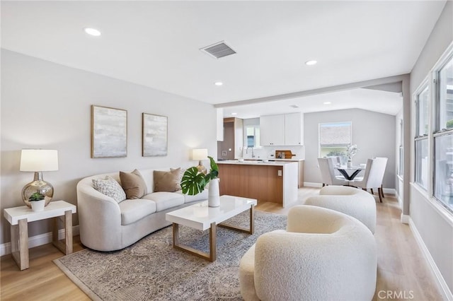 living room with visible vents, recessed lighting, baseboards, and light wood-type flooring