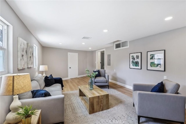 living area with recessed lighting, visible vents, electric panel, and light wood-type flooring