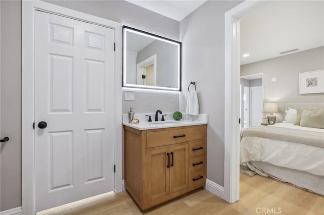 bathroom featuring baseboards, visible vents, wood finished floors, and vanity