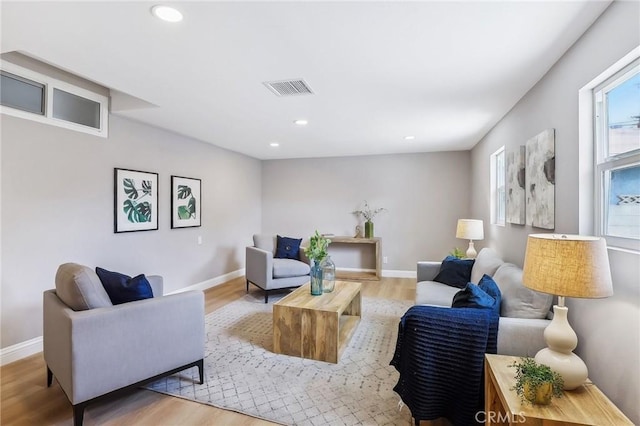 living area with visible vents, recessed lighting, light wood finished floors, and baseboards