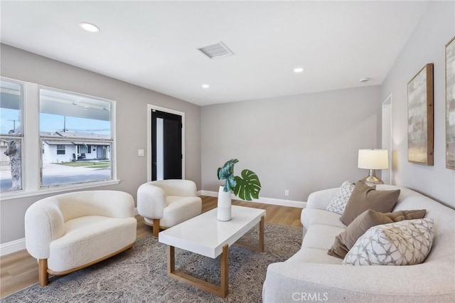 living room featuring recessed lighting, baseboards, visible vents, and wood finished floors