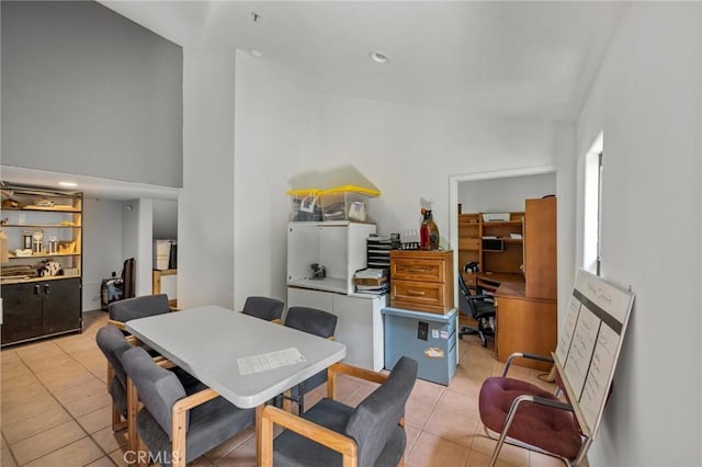 dining room with light tile patterned floors and high vaulted ceiling