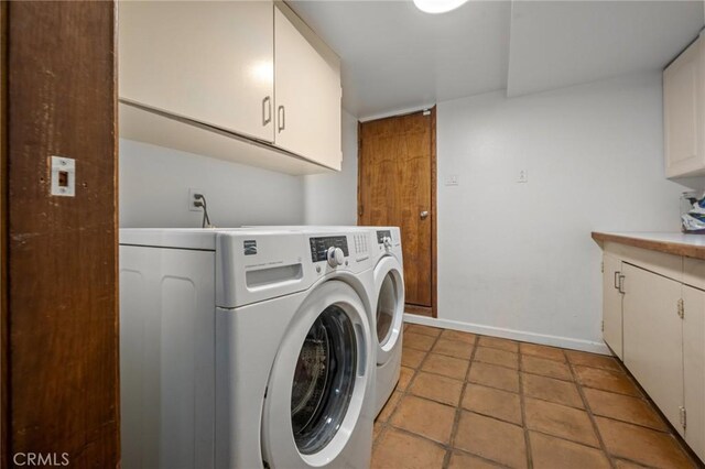 laundry area featuring washer and clothes dryer, cabinet space, and baseboards