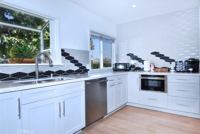 kitchen featuring tasteful backsplash, a healthy amount of sunlight, appliances with stainless steel finishes, and a sink