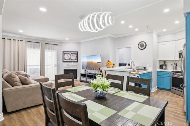 dining room featuring light wood-type flooring, recessed lighting, and ornamental molding