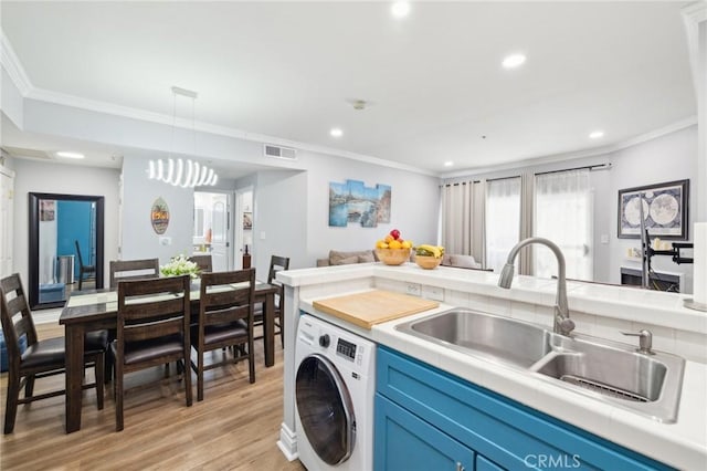 laundry room with washer / clothes dryer, ornamental molding, and a sink