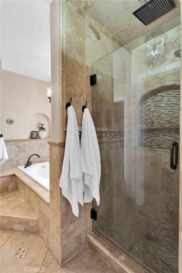 bathroom featuring a shower stall and a garden tub