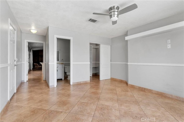 unfurnished bedroom featuring a closet, ceiling fan, baseboards, visible vents, and light tile patterned flooring