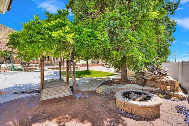 view of yard featuring fence and an outdoor fire pit