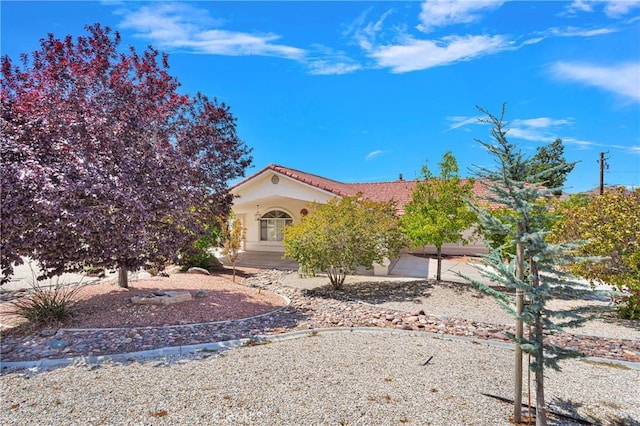 view of front of property with stucco siding, a garage, and a tile roof