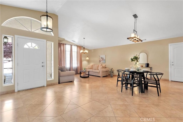 interior space featuring light tile patterned floors, a notable chandelier, and vaulted ceiling