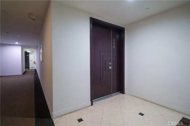 hallway with baseboards and light tile patterned floors