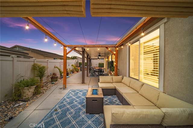patio terrace at dusk with ceiling fan, outdoor dining space, an outdoor hangout area, and a fenced backyard