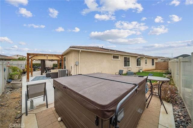 exterior space with a patio, a fenced backyard, solar panels, and a hot tub