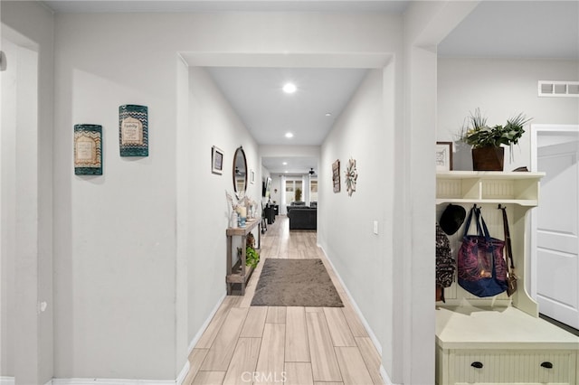 corridor with baseboards, visible vents, light wood-style floors, and recessed lighting