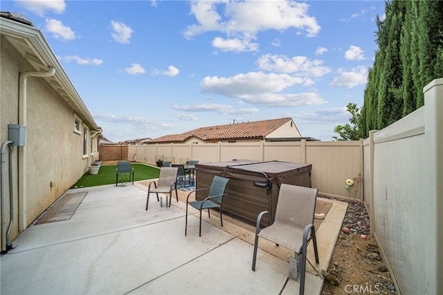 view of patio with a fenced backyard and a hot tub