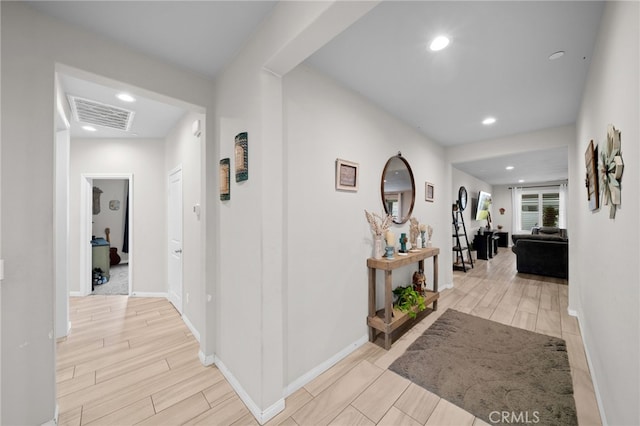 hallway featuring recessed lighting, visible vents, light wood-style flooring, and baseboards