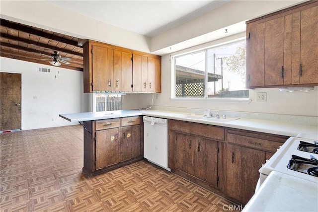 kitchen featuring visible vents, white appliances, light countertops, and a sink