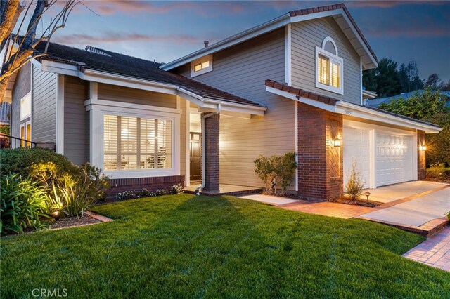 5005 Stonehaven Dr, Yorba Linda, CA 92887 - traditional-style home with a lawn, driveway, an attached garage, and brick siding