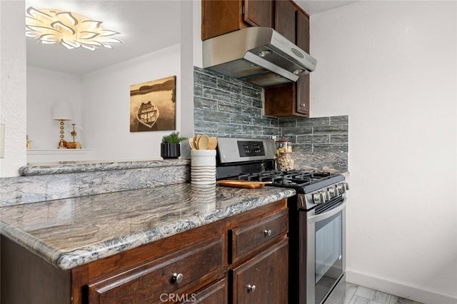 13461 Whittier Ln, Garden Grove, CA 92844 - kitchen with dark brown cabinetry, stainless steel gas range oven, under cabinet range hood, stone counters, and backsplash