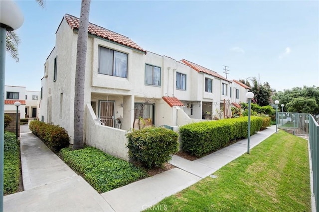 13461 Whittier Ln, Garden Grove, CA 92844 - view of front of house featuring fence, a tiled roof, a front lawn, and stucco siding