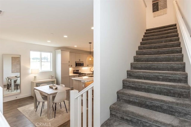 staircase with visible vents, recessed lighting, and wood finished floors