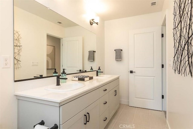 full bath with tile patterned floors, visible vents, double vanity, and a sink