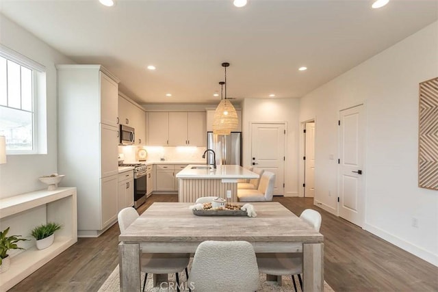 dining room with dark wood-type flooring, recessed lighting, and baseboards