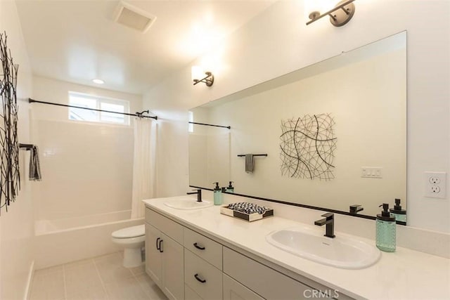 full bathroom with toilet, double vanity, a sink, and visible vents