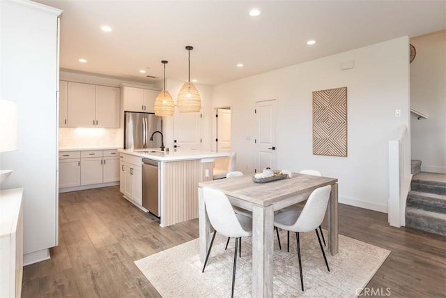 dining room featuring stairway, light wood-type flooring, recessed lighting, and baseboards