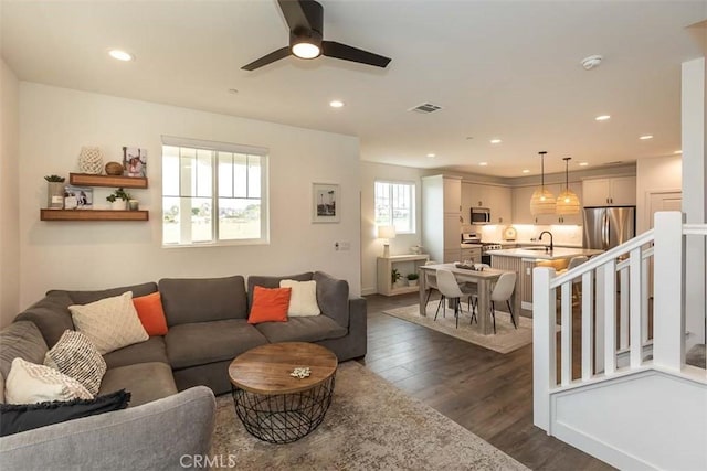 living area featuring visible vents, ceiling fan, baseboards, recessed lighting, and dark wood finished floors