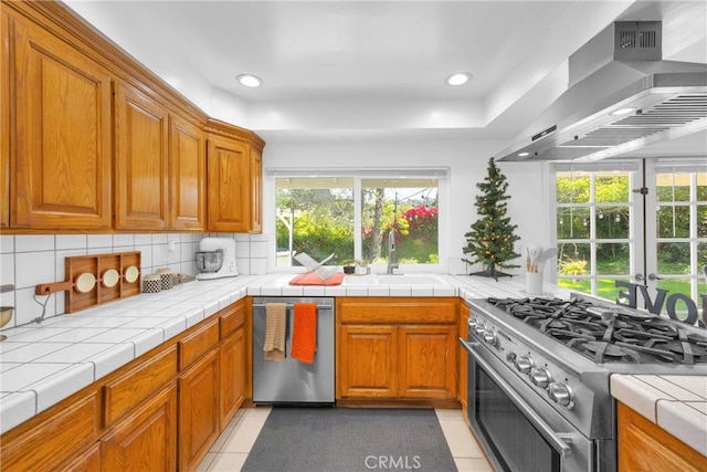 2871 N Wyngate Rd, Orange, CA 92867 - kitchen featuring decorative backsplash, a healthy amount of sunlight, wall chimney exhaust hood, a sink, and appliances with stainless steel finishes