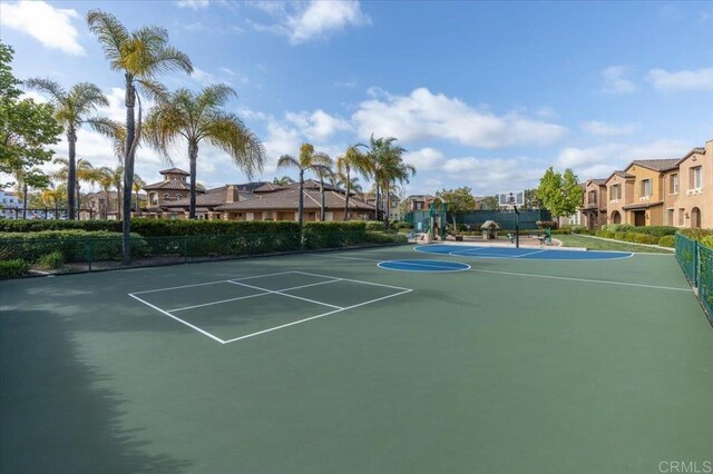 view of basketball court featuring a residential view, community basketball court, and fence