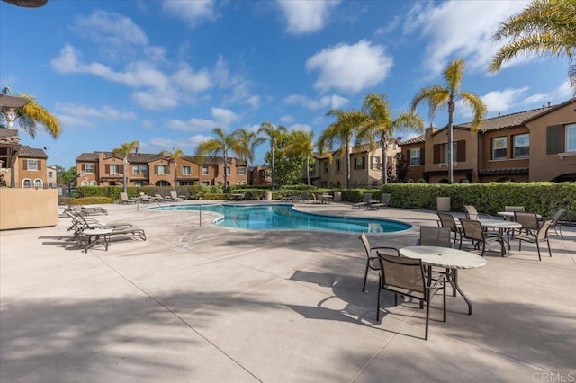 community pool with a residential view and a patio