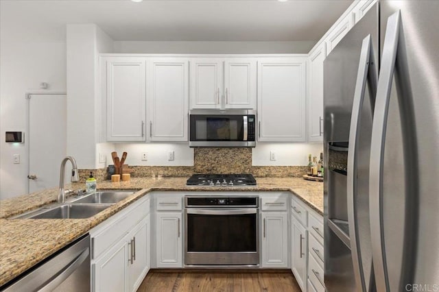 kitchen with white cabinetry, stainless steel appliances, and a sink