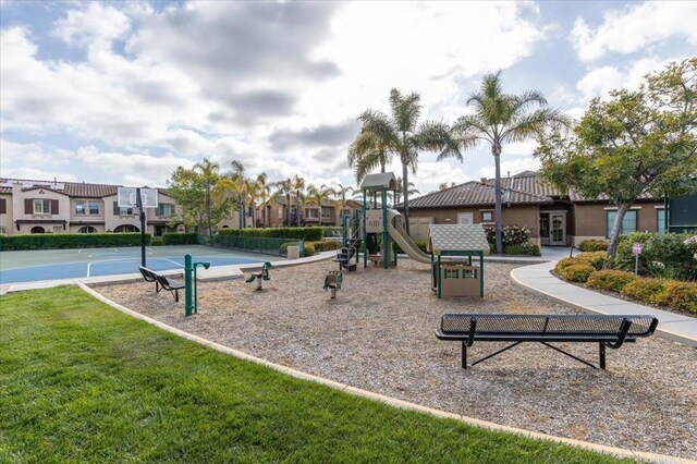 communal playground featuring a lawn, french doors, and a residential view