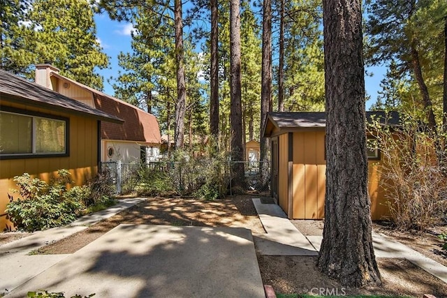 exterior space with an outdoor structure, a storage unit, a patio area, and fence