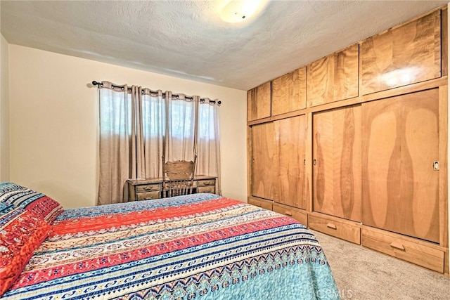 bedroom with carpet floors and a textured ceiling