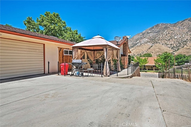 exterior space featuring fence, a gazebo, and a mountain view