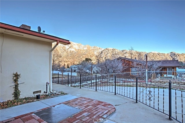 view of patio / terrace featuring fence and a mountain view