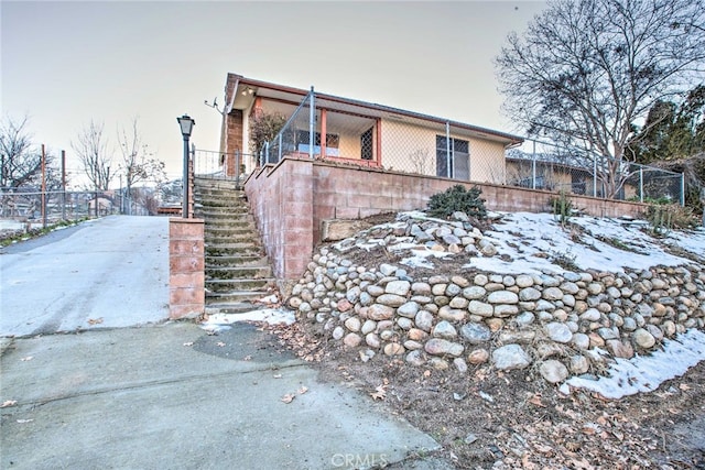 view of side of property with stairway and fence